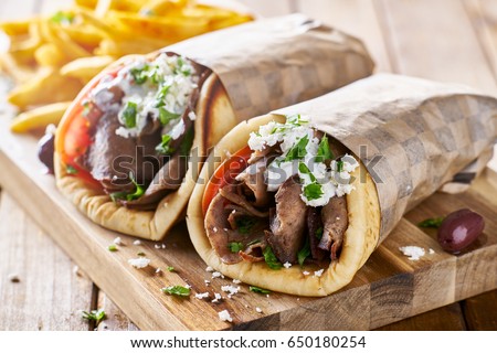 greek lamb meat gyros with tzatziki sauce, feta cheese and french fries Royalty-Free Stock Photo #650180254