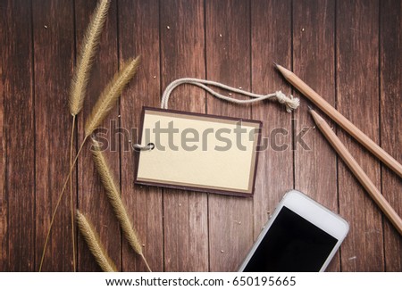 Blank labels and pencils,rices,smart phone on wooden background