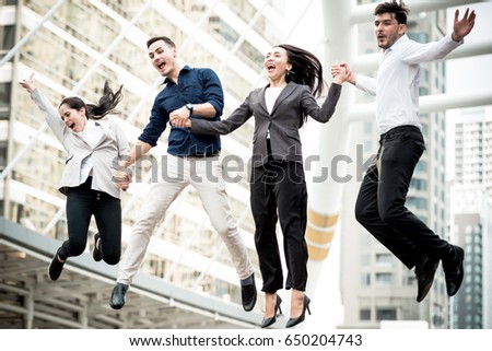 Young business team jumping for huge celebration of successful team work. Taken outdoor in afternoon with soft vintage effect. Happy multi race with Asian, Middle Eastern, white people concepts. Royalty-Free Stock Photo #650204743