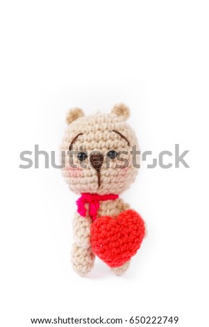 crochet doll of a bear holding a red heart, concept of love and romantic for Valentine's day or happy anniversary.