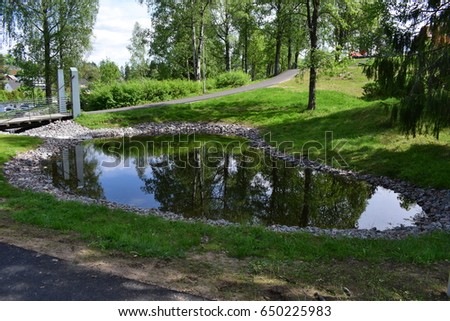 Beautiful nature summer sunny picture with water pond in the middle of the city park scenery - Kongsvinger, Norway