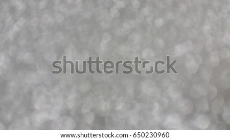 Fresh flower wrapping paper or fabric gift wrapping paper is not focus. Abstract background with bokeh. White bokeh lights on gray background.