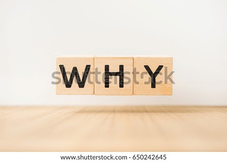 Surreal abstract geometric floating wooden cube with vocabulary "WHY" on wood floor and white background