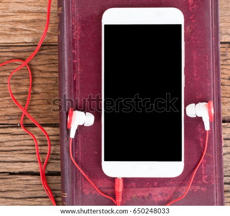 smartphone with ears plug head phone placed on aged wooden background