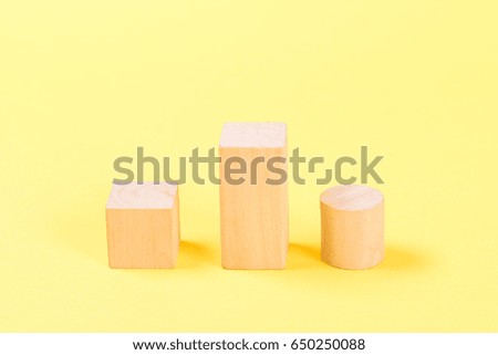 Wooden building blocks on the yellow background.