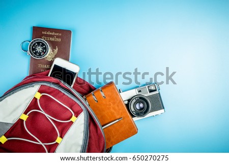 Traveler Backpack with travel accessories on blue copy space for Backpacker Vacation and Travel concept with camera passport mobile phone notebook and compass. Royalty-Free Stock Photo #650270275