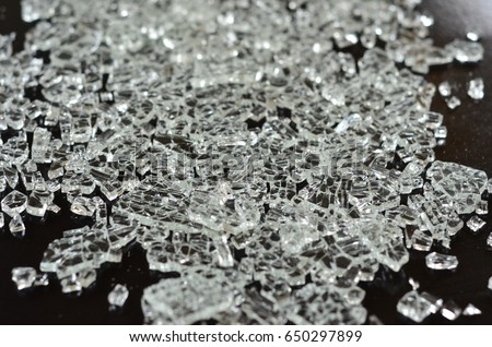 A close-up of broken pieces of tempered glass. Royalty-Free Stock Photo #650297899