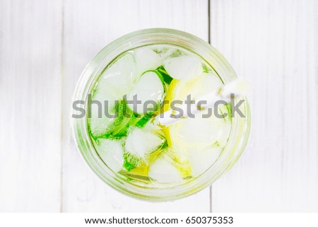 Sassy diet water. Cucumber, lemon, mint lemonade in glasses on white wooden table. Top view, Selective focus