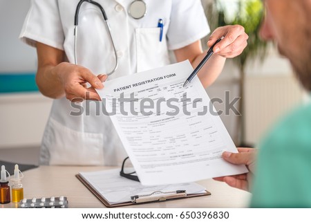 Doctor receiving patient registration form in hospital