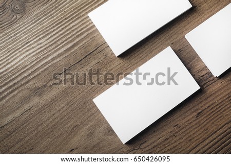 Photo of blank business cards on wood table background. Template for ID. Mock up for branding identity. Top view.