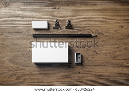 Photo of business card, pencil, eraser and sharpener on wood background. Blank stationery elements. Mock-up for branding identity. Studio shot. Top view.