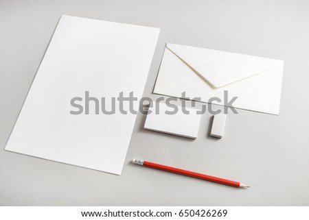 Photo of blank stationery set on paper background. Corporate identity template for placing your design. Blank letterhead, business cards, envelope, eraser and pencil. Top view.