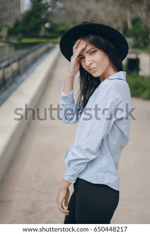young model brunette on the street in a hat