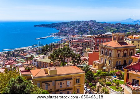 Aerial view from hilltop over Naples, Italy. View on Old Town of Naples from Castel Sant'Elmo. Sunny spring day.  Many colorful buildings and gulf of Naples. Houses built close to each other, closely. Royalty-Free Stock Photo #650463118