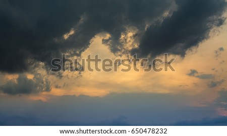 Sunset sky with black cumulus rain clouds for background content.