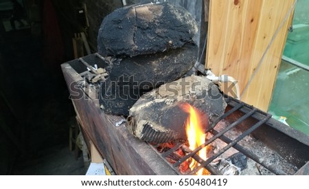Ancient Food in China, clay covered fresh chicken with spicy grilled on fire.