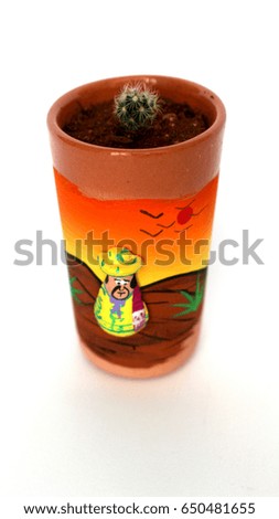 Tiny cactus in a tequila cup with mexican man drawing