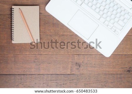 White laptop computer with notebook on wooden table, Workspace concept