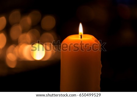 candle over blurred bokeh in darken room,Image for spiritual concept.