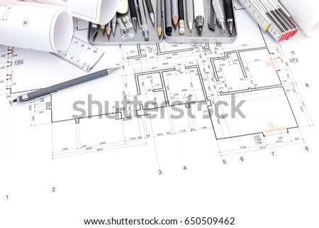 set of various drawing tools for designer on paper with graphical plan and blueprint rolls