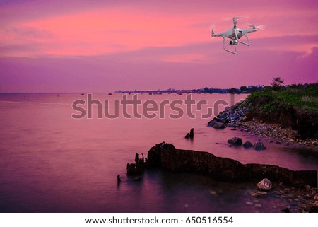 drone copter flying with digital camera.Drone with high resolution digital camera. Flying camera take a photo and video.The drone with professional camera takes pictures of the Twilight Sea.