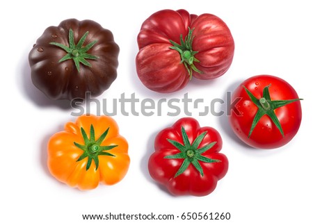 Fresh ripe globe and ribbed heirloom tomatoes with sepals, whole. Top view, clipping paths for each tomato, shadows separated Royalty-Free Stock Photo #650561260