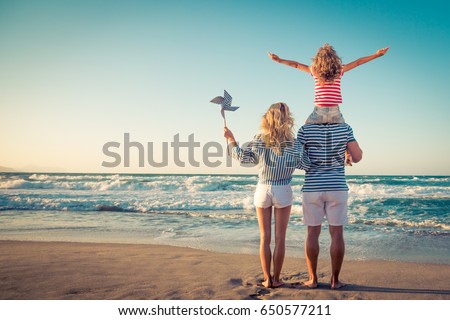 Happy family on the beach. People having fun on summer vacation. Father, mother and child against blue sea and sky background. Holiday travel concept Royalty-Free Stock Photo #650577211
