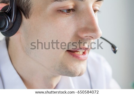 Call center agent talking to a client using headset Royalty-Free Stock Photo #650584072