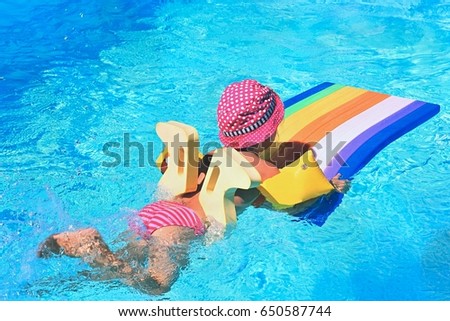 Young girl swiming in the pool. Clear water and hot sunny day. Summer background for traveling and vacation - holiday idyllic..