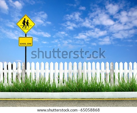 School warning sign with white fence and blue sky