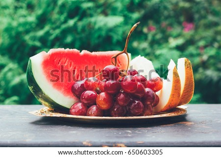 summer fruit berry still life with slices of watermelon, melon and grape bunch on the table