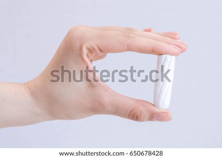 Woman's hand holding clean cotton tampon close-up. Young woman preparing menstruation time. Soft tender protection woman critical days, gynecological. Medical hygiene conception and protection