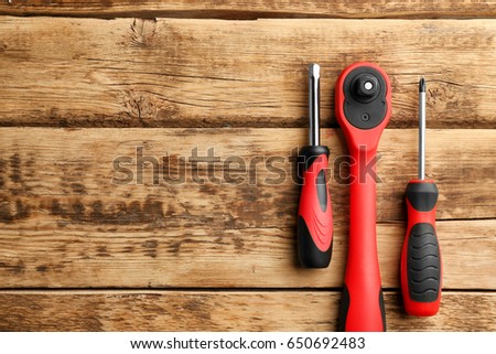 Ratchet and screwdrivers on wooden background