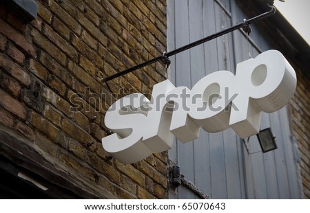 White coloured shop sign in front of a trade building