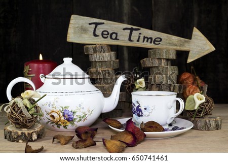 Cup of Tea and Teapot On Wooden Table. Arrow Sign With Text, Tea Time Written On It in The Background