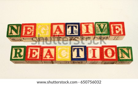 The term negative reaction displayed visually using colorful wooden blocks