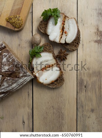 A beautiful picture of food. Two sandwiches with lard and mustar