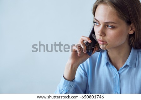 Woman talking on the phone on a light background                               