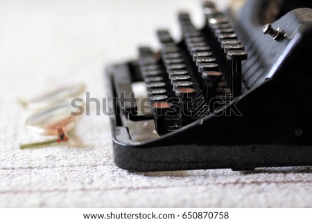 Vintage typewriter, glasses on linen tablecloth, side view close up