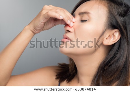 The asian woman hurts her nose because she has cold. Royalty-Free Stock Photo #650874814