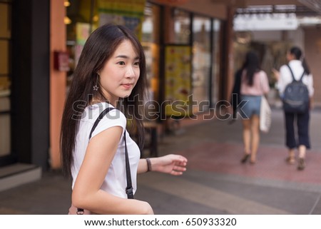 Young Asian woman walking on the street for shopping or looking to something in the city