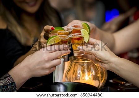 Girls making a toast with tequila shots Royalty-Free Stock Photo #650944480