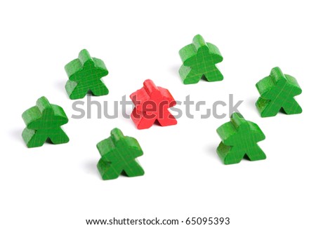 Red wooden figure among green ones on white background