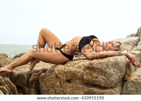 young slim teen girl do gymnastic exercise at white sand beach of tropical sea under blue sky.Young gymnast on seashore