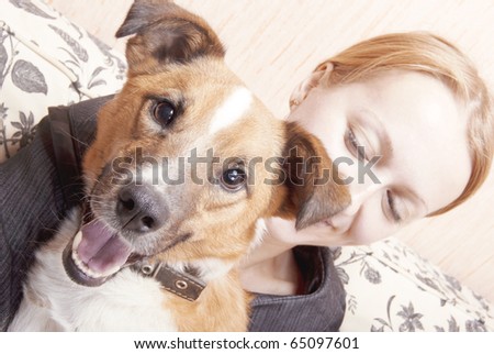 Young woman playing on a sofa with a little dog