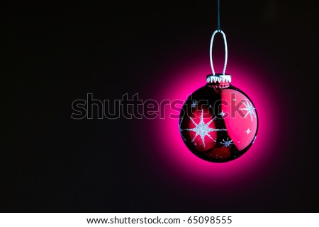 purple Christmas ball on black with copy-space