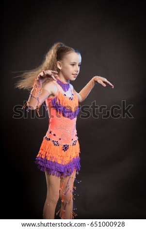 Portrait of a blond girl in orange and purple dance costume for stage performance