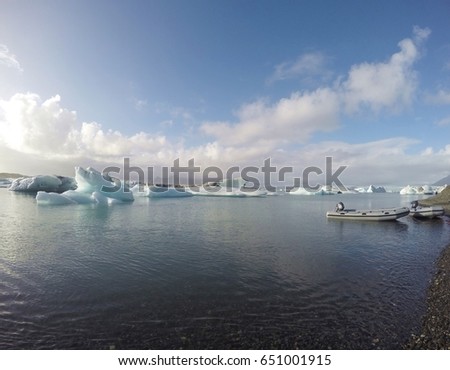 Jokulsarlon Glacier Lagoon in Iceland. The beautiful of icebergs in the lagoon and the blue sky with white clouds. Boats providing for tourist who want to go closer to the icebergs.