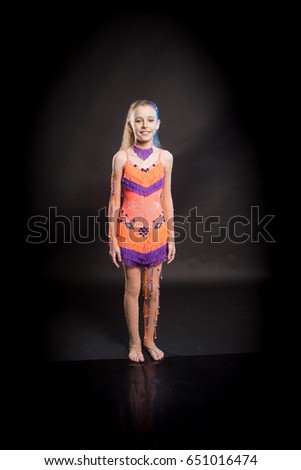 Portrait of a blond girl in orange and purple dance costume for stage performance