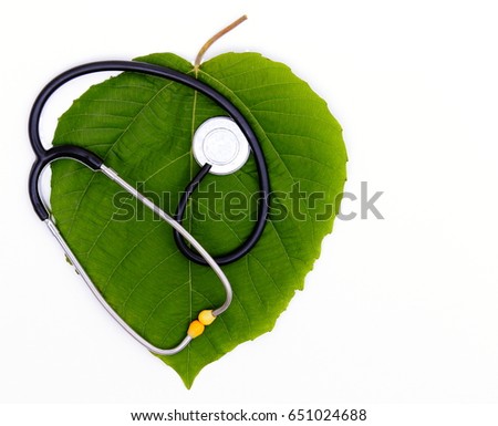 Green Health Concept. Stethoscope over green leaf isolated on white   